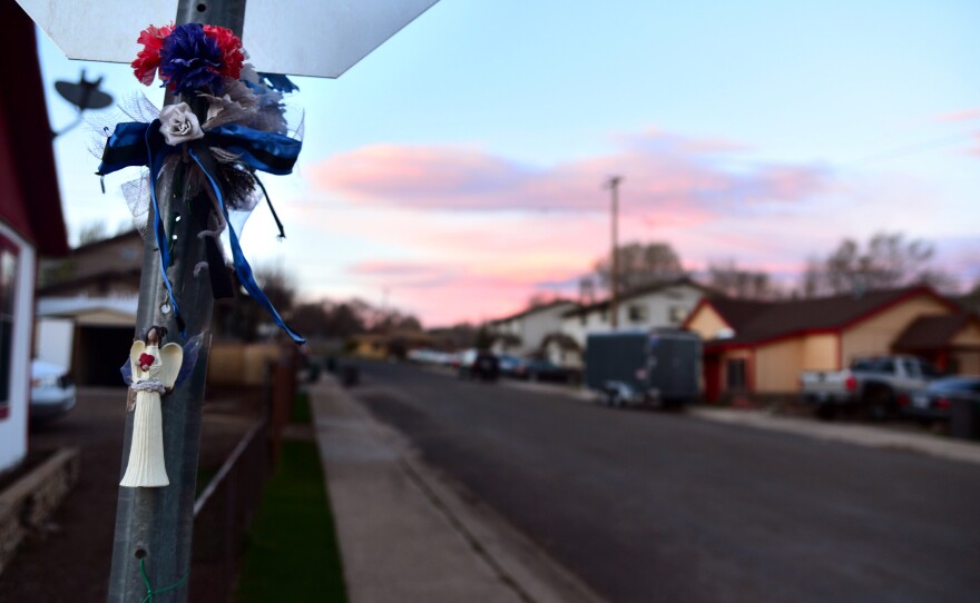 An angel and flowers are tied to a stop sign on the corner of West Clay Avenue in Flagstaff, near the location where Stewart was shot.