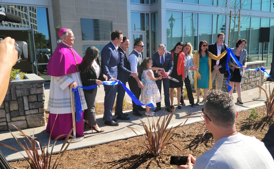 Deacon Jim Vargas is joined by 7-year old Abigail Fish in cutting the ribbon to officially open the new Saint Teresa of Calcutta Villa on February 10, 2022.