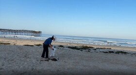 Vi Nguyen picks up trash on Pacific Beach in this undated photo. Nguyen is a local pediatrician who has been picking up plastic along San Diego's coastline for the past seven years.