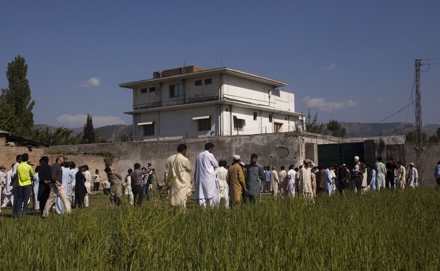 Pakistanis along with international and local media gather outside Osama Bin Laden's compound, a day after the successful raid by U.S. Special Forces.