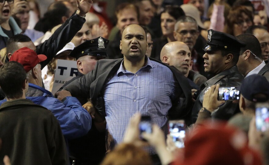 Law enforcement officers escort a man from a campaign event for Republican presidential candidate Donald Trump in Worcester, Mass., on Wednesday.