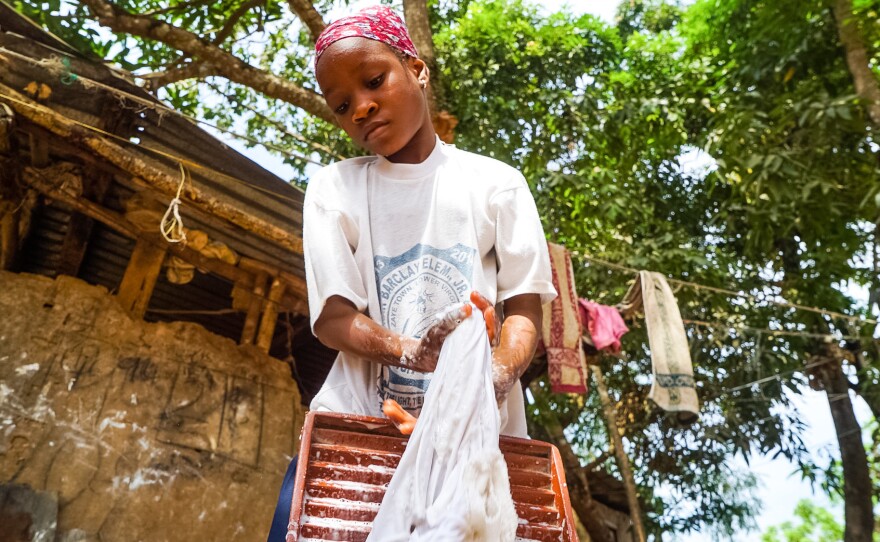 Ramatu Shellu, 8, does the laundry at her parents' home.