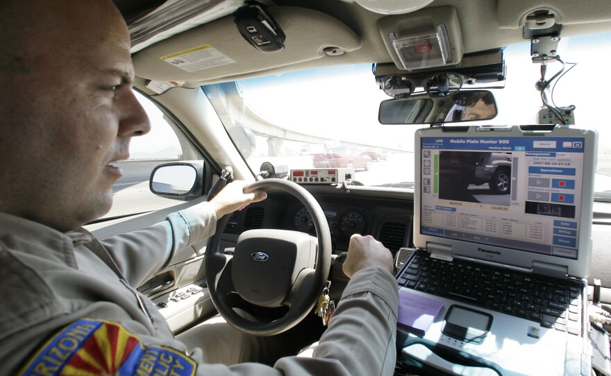 An Arizona Department of Public Safety officer keeps an eye on his dashboard computer as it reads passing car license plates.