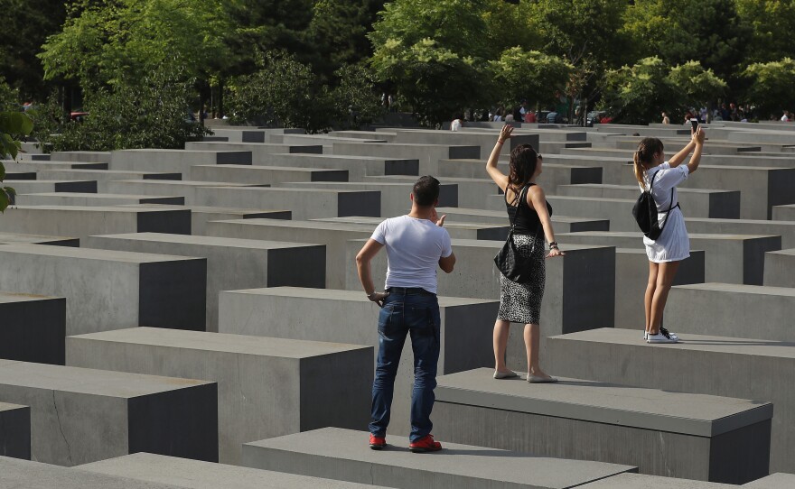 Visitors photograph each other while standing on concrete slabs at the Holocaust Memorial in Berlin on Aug. 13.