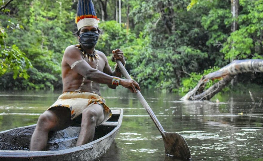 A Colombian Huitoto man sails on a raft along the Takana river in Leticia, Amazonas department, Colombia, on May 20, during the coronavirus pandemic.