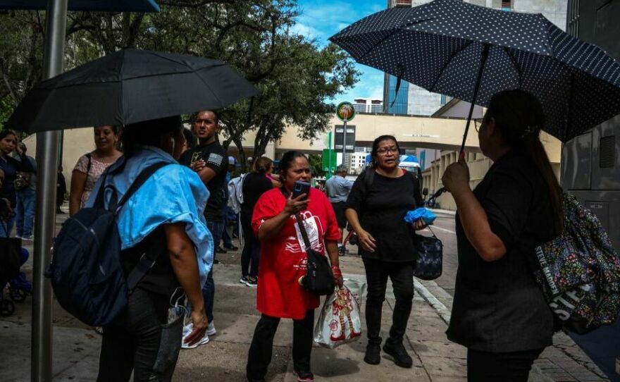 Staying out of direct sun as much as possible can help prevent heat-related illness. Look for shade or make your own with an umbrella, like these pedestrians waiting for a bus during a heat wave in Miami on June 26.