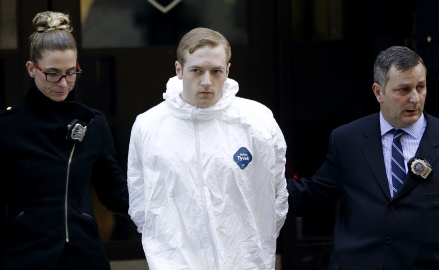 James Harris Jackson is escorted out of a police precinct in New York on March 22. Police said Jackson, accused of fatally stabbing a black man in New York City, told investigators he traveled from Baltimore specifically to attack black people.