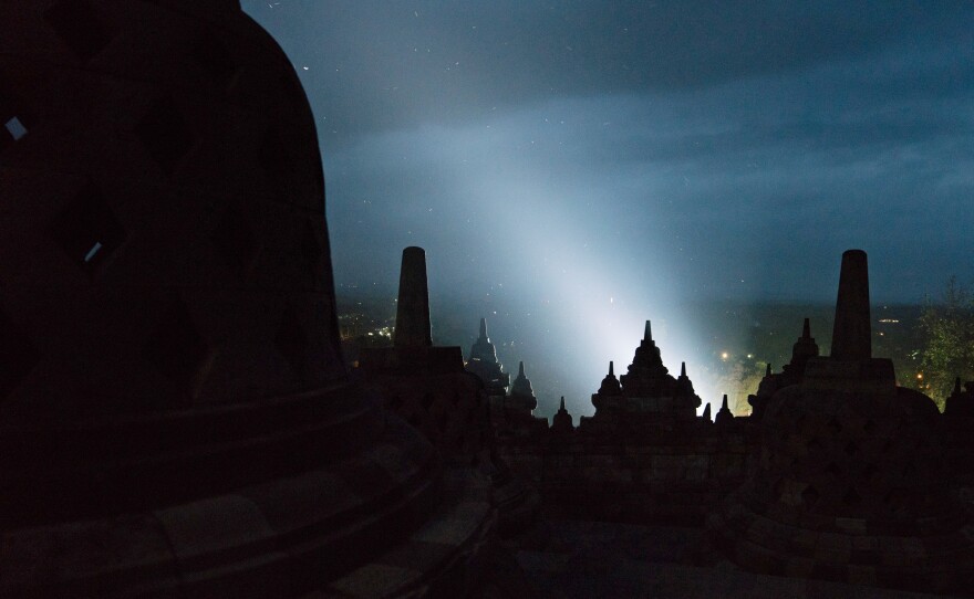Lights from a fashion show at a hotel that sits at the base of the temple illuminate Borobudur. The Buddhist temple was restored with help from UNESCO.