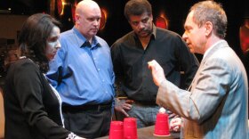 (From left to right) Neuroscientists Susana Martinez-Conde and Stephen Macknik and "NOVA scienceNOW" host Neil deGrasse Tyson observe Teller, the silent half of comedy magic duo Penn & Teller, as he performs his famous cups and ball trick.