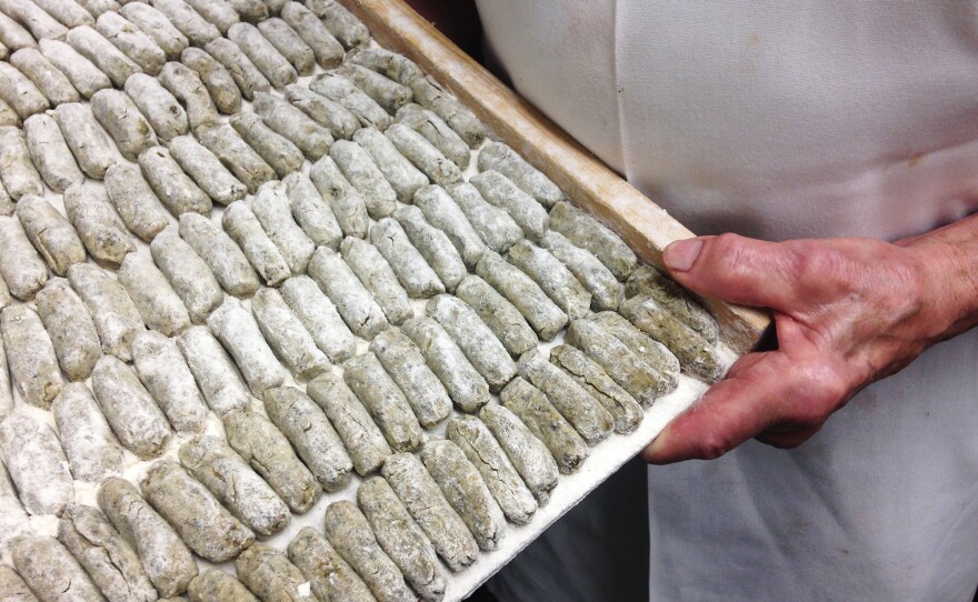 Clemente Cittoni holds a tray of malfatti.