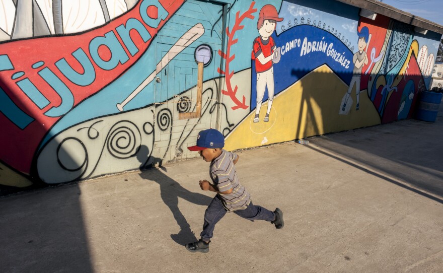 A little boy plays in front of a mural at the Tijuana Municipal little league fields dedicated to Adrian Gonzalez who used to play on those fields, Tijuana, June 15, 2023.