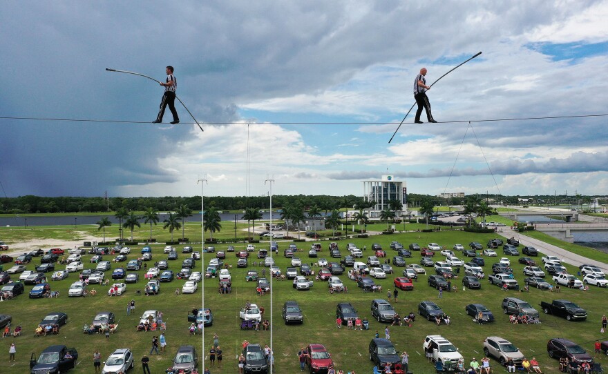 People parked their cars outside in a distanced tailgater in June to watch high-wire artists and cousins Nik (left) and Blake Wallenda perform at Nik Wallenda's Daredevil Rally, billed as the world's first drive-in stunt show at Nathan Benderson Park in Sarasota, Fla.