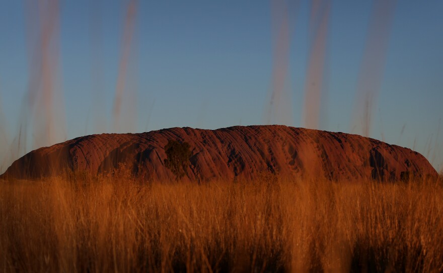 Uluru, seen at sunset from a designated viewing area earlier this year in Australia's Uluru-Kata Tjuta National Park. The sandstone monolith will be closed to climbers permanently Saturday, in a blow to tourists' aspirations and a boon to the aboriginal peoples who consider it sacred.