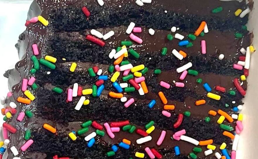 A slice of the 12-layer chocolate cake known as "Bruce" is adorned with colorful sprinkles at the British bakery Get Baked. But regulators say the topping is illegal, as it includes a color additive that is permitted only for other uses.