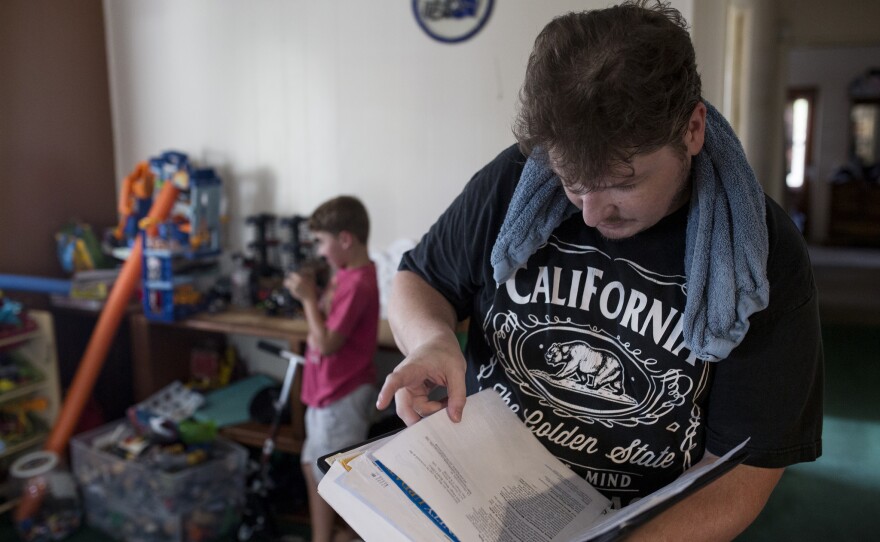 Alex Masters examines papers relating to the groundwater contamination beneath his home in El Cajon. Harmful vapors from the pollution are in his home. July 19, 2017