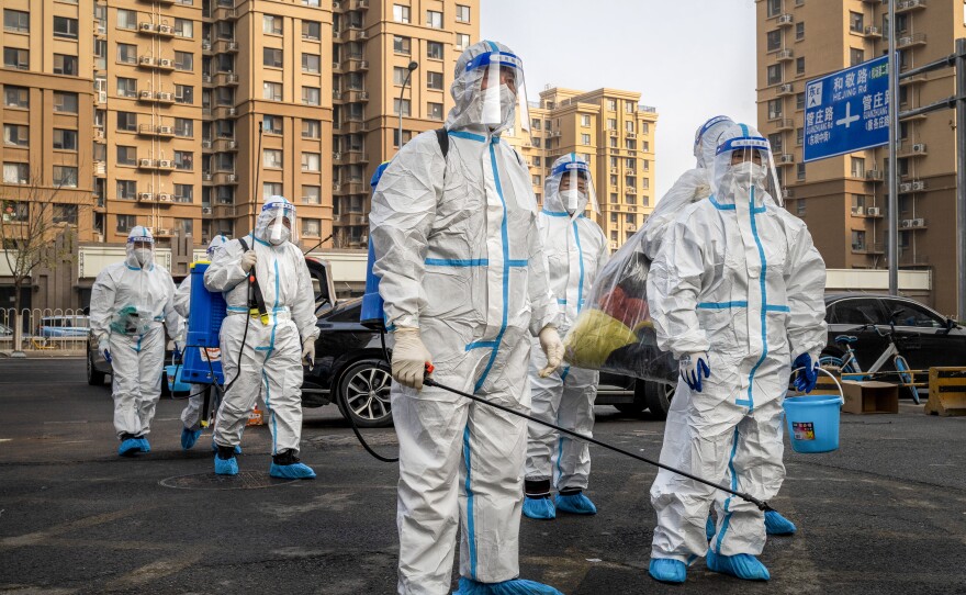 Workers wear protective gear in a Beijing neighborhood placed under lockdown during China's "zero-COVID" policy, which ended in late 2022.