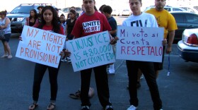 Young activists concerned with irregularities on Election Day and the volume of unprocessed ballots hold signs outside of the Maricopa County elections department facility where ballots are being counted.