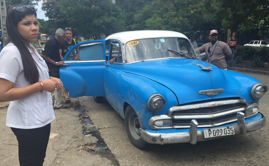 Fewer taxis are on the road since Cuba's austerity measures took effect this summer. Medical student Claudia Arango waits at a transfer stop.