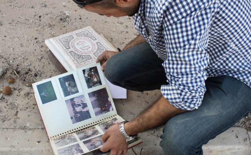 Businessman Taher Bahoo lingers over family photo albums he salvaged from his home, which was ransacked by ISIS.