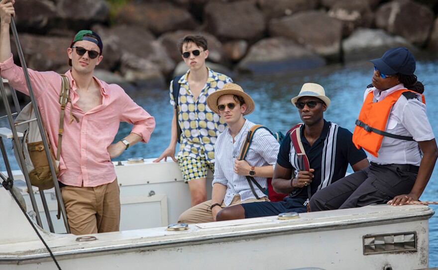 Hugo Pickford (HUGH COLES), Jamie Santisuk (COLIN RYAN), Finlay McEwan (LEWIS REEVES), Ollie Gordon (BUOM TIHNGANG) in a scene from DEATH IN PARADISE: Season 10,