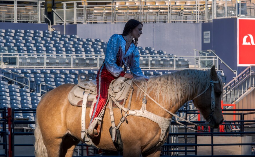 A woman in a shiny outfit sits on a horse at San Diego Rodeo inside Petco Park, Jan. 15, 2026.