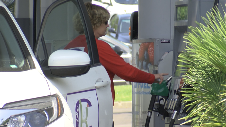 Women is pictured pumping gas in San Diego on June 30, 2021. 