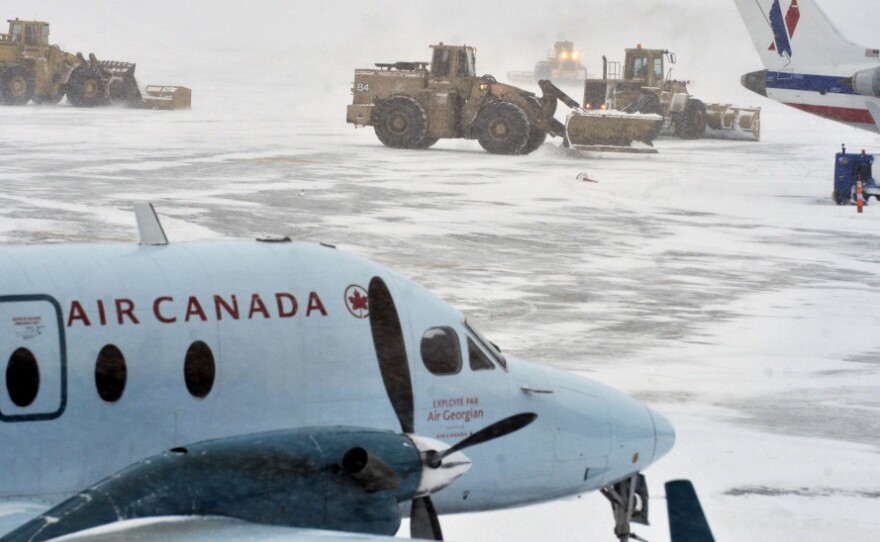 Plows cleared the tarmac around planes as a heavy snowstorm continued Monday morning at Bradley International Airport in Windsor Locks, Conn. U.S. airlines scrambled to rebook passengers on thousands of canceled flights — more than 1,400 out of the New York City area's three major airports alone — but said they didn't expect normal service to resume until Tuesday.