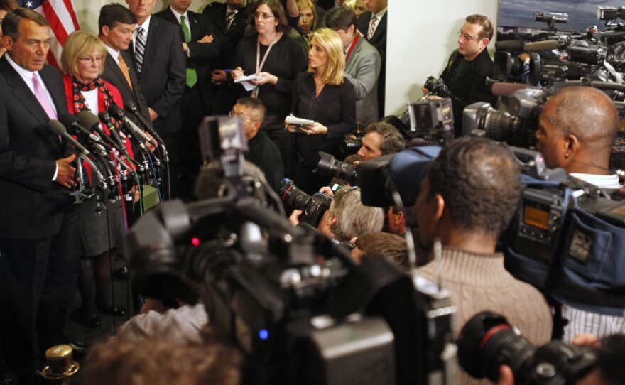 Surrounded by news media, House Speaker John Boehner announces a deal was reached, avoiding a government shutdown.