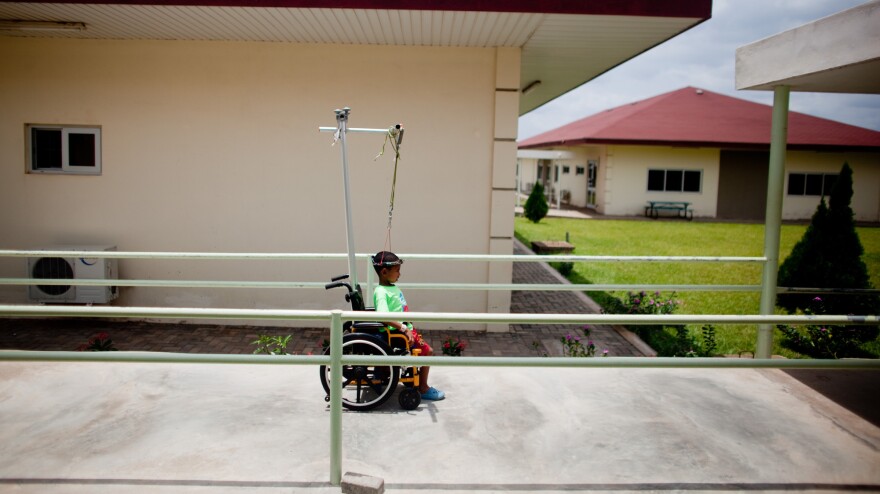 Sisay Gudeta makes his way to the dining center at the Foundation for Orthopedics and Complex Spine hospital in Accra, Ghana, in March. The metal halo screwed into his skull stretches Sisay's spine and back. During the month of December, he grew about 2.5 inches to 3-foot-5.
