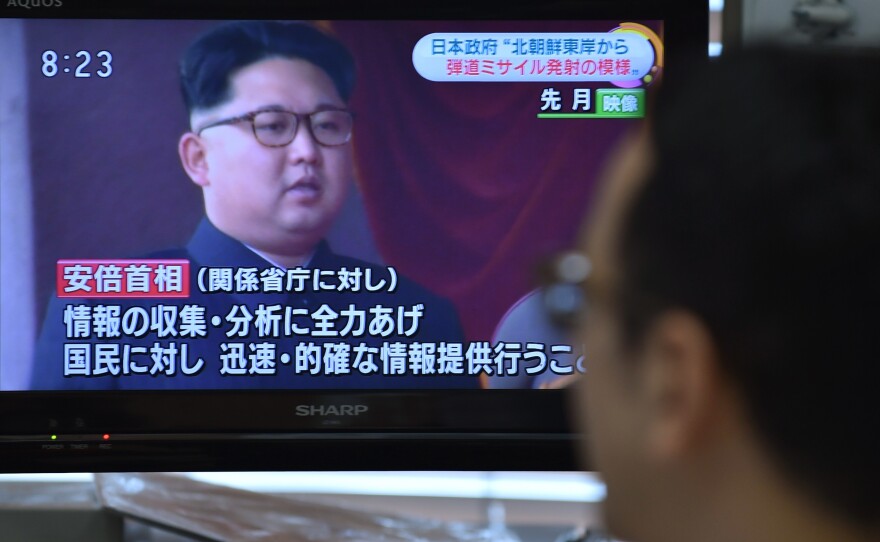 A man looks at a television reporting on North Korea's missile launching in Tokyo. North Korea test-fired what appeared to be two medium-range Musudan missiles in quick succession.