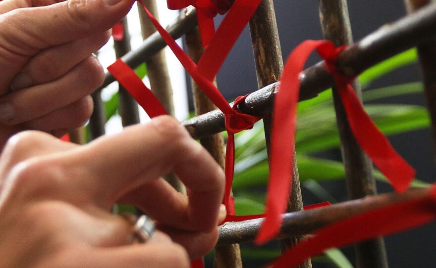 A conference attendee ties a ribbon in tribute to those who lost their lives on flight MH17 during the International AIDS Conference in Melbourne on Sunday. At least six delegates traveling to the conference were on board.
