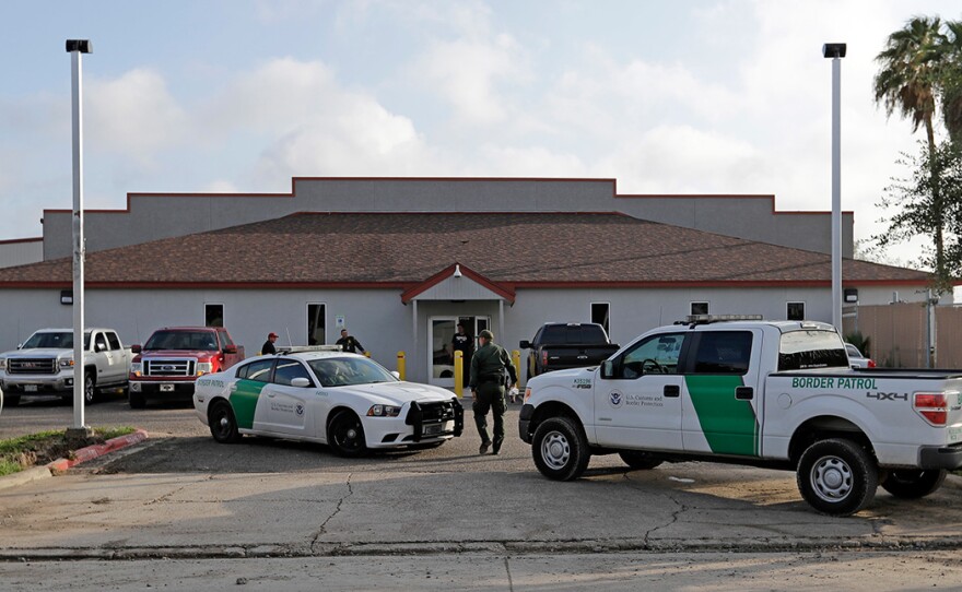 In this Saturday, June 23, 2018, file photo, a U.S. Border Patrol Agent walks between vehicles outside the Central Processing Center in McAllen, Texas.