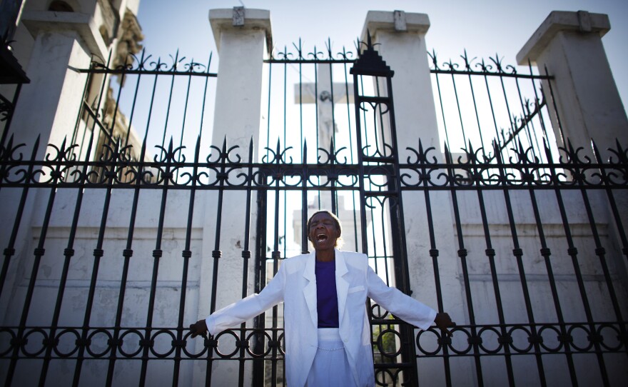 A woman cries in front of the gates of the destroyed cathedral in Port-au-Prince. The country's devastating earthquake on Jan. 12, 2010, destroyed hundreds of thousands of structures, including many government and public buildings.