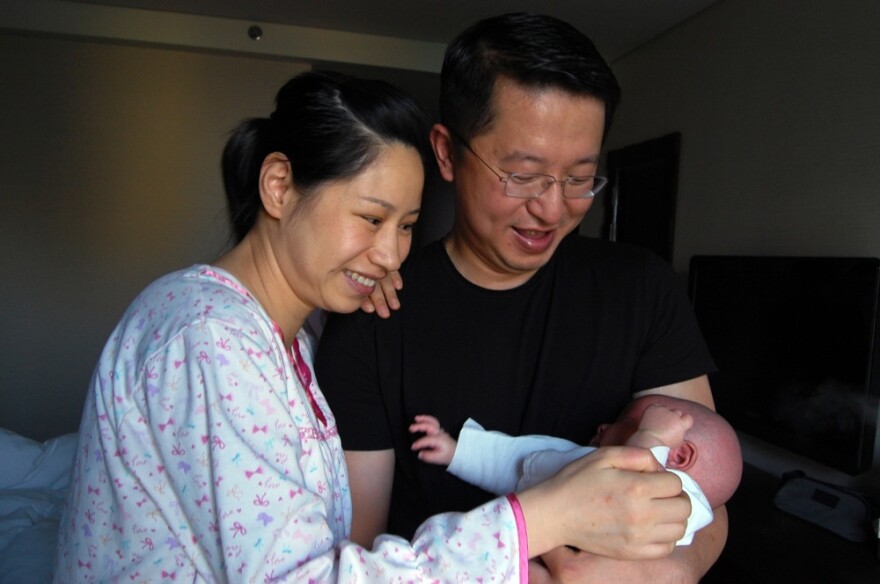 New parents Wu Lili (left) and Mo Shiwei hold their 29-day-old baby boy, nicknamed Momo, at the Weige Center in Beijing. The new mother is participating in the Chinese tradition of "sitting the month," in which she follows certain rules, such as not going outside, not washing her hair or showering, and only eating certain foods.