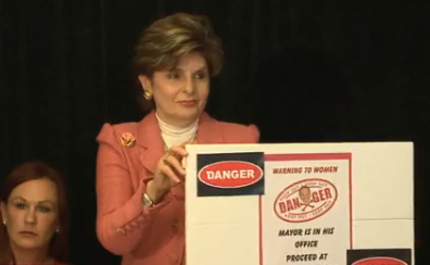 Attorney Gloria Allred holds up the warning sign she proposes the city of San Diego hang outside the mayor's office.