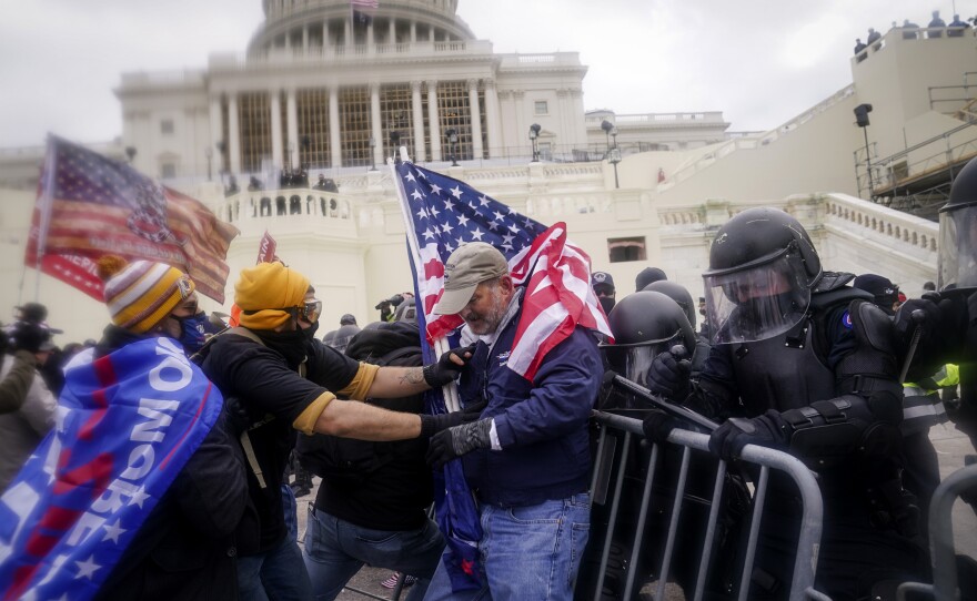 Rioters try to break through a police barrier at the Capitol on Jan. 6, 2021, in Washington.