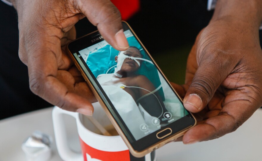 Oluremi Kehinde shows a photo of a teenage girl forced to work as a prostitute in Russia. She was hospitalized because of internal injuries.