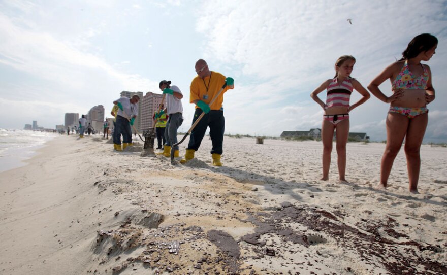 BP workers shovel oil and sand along a 700-yard long strip of oil that washed up on the beach in Gulf Shores, Ala., on Friday.