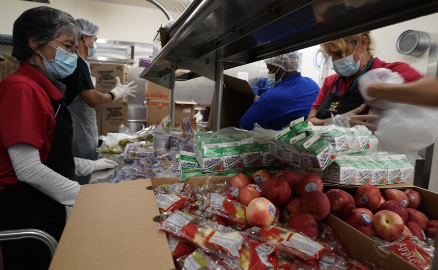 Los Angeles Unified School District food service workers from left, Tomoko Cho, Aldrin Agrabantes, April Thomas, and Marisel Dominguez, pre-package hundreds of free school lunches in plastic bags on Thursday, July 15, 2021, at the Liechty Middle School in Los Angeles.