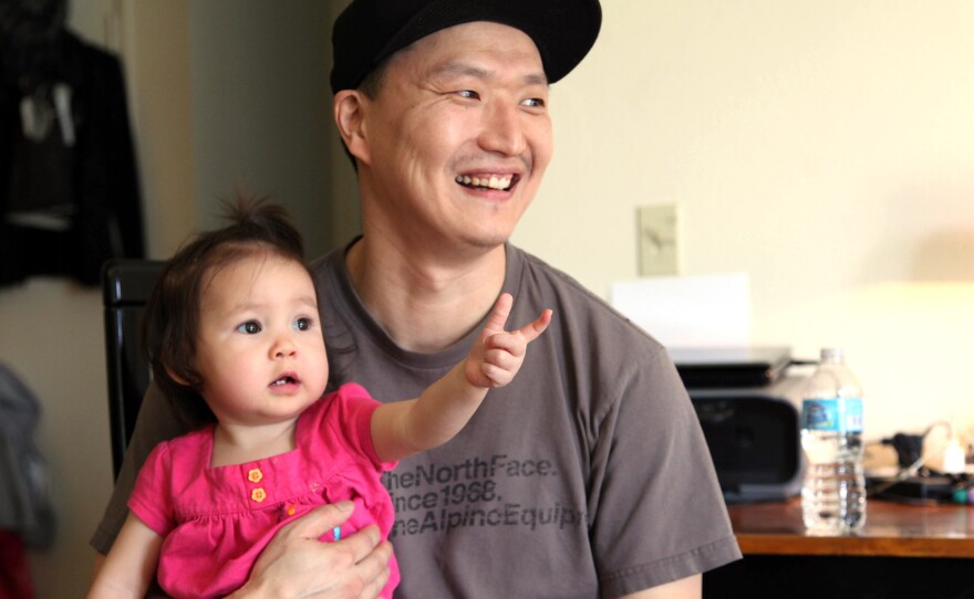 South Korean adoptee Adam Crapser poses with his 1-year-old daughter, Christal, in the family's living room in Vancouver, Wash., in 2015. Crapser, who was flown to the U.S. 37 years ago and adopted by an American couple at age 3, has been ordered deported back to South Korea.