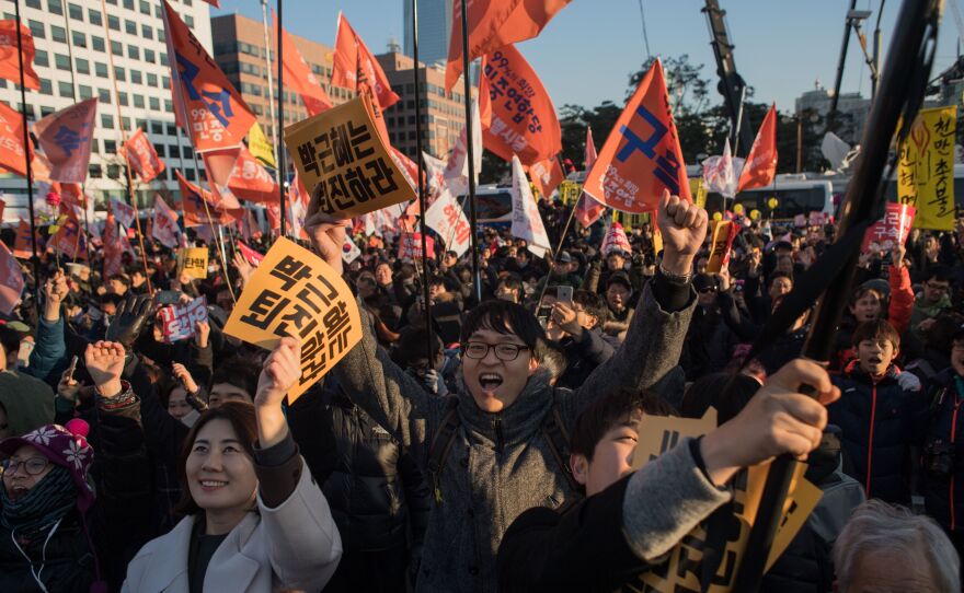 Demonstrators celebrate after the South Korean Parliament voted to impeach President Park Geun-Hye, as huge crowds gathered outside the National Assembly in Seoul on Friday.