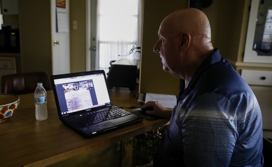 Mike Noel looks at photos from his archive of the floods on Heritage Plantation streets, Wednesday, June 8, 2022, in Vero Beach.