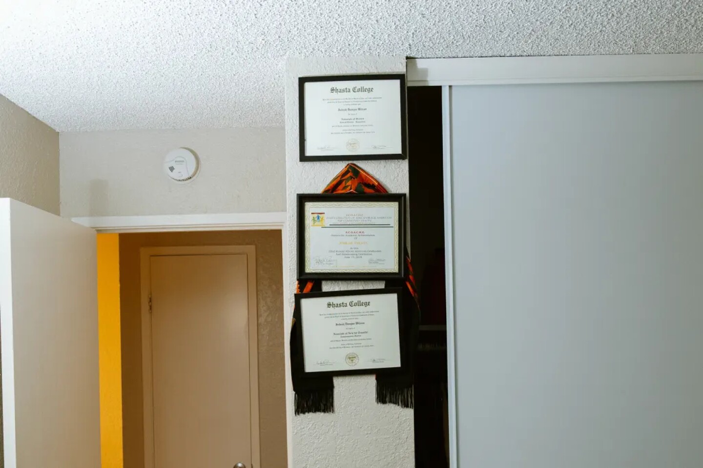 Academic degrees from community college hang on the bedroom wall of Wilson’s off-campus apartment on Oct. 17, 2025.