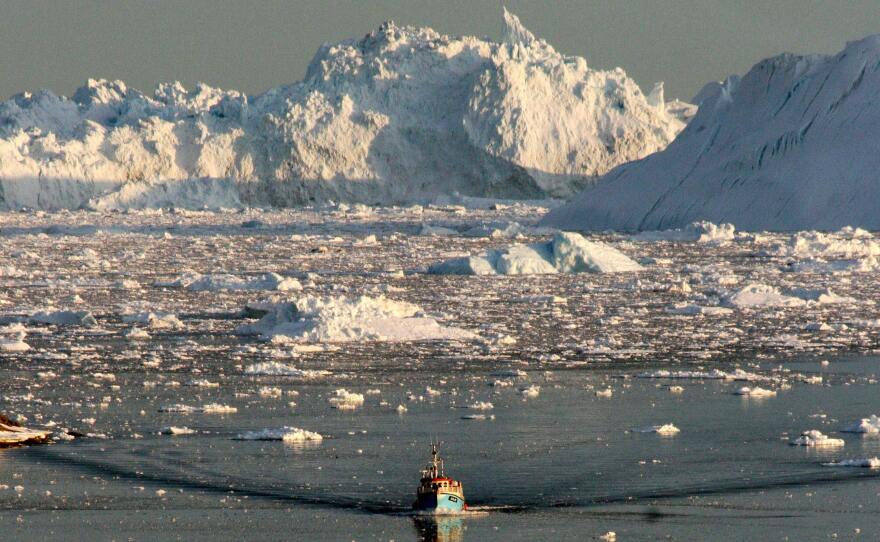 A boat skims through the melting ice in the Ilulissat fjord in August 2008, on the western coast of Greenland.