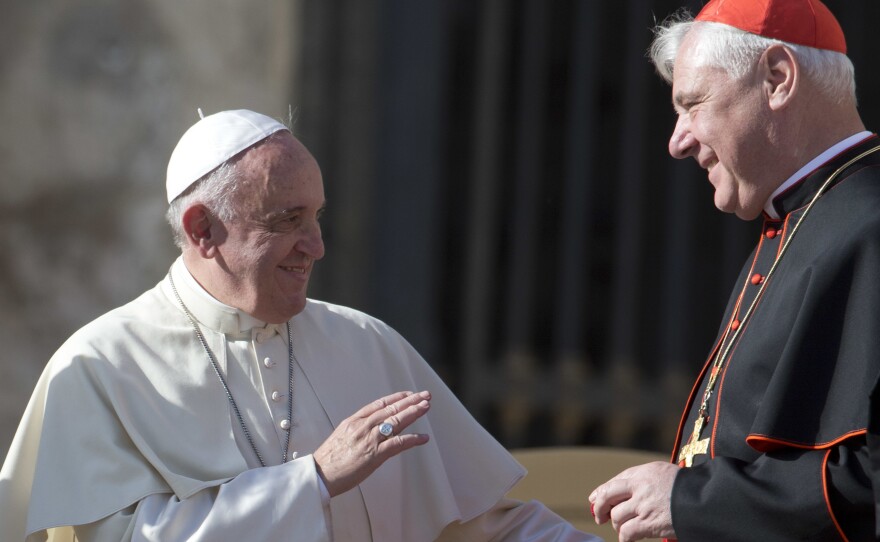 Pope Francis talks with Cardinal Gerhard Ludwig Mueller in St. Peter's Square at the Vatican on Wednesday, Nov. 19, 2014.