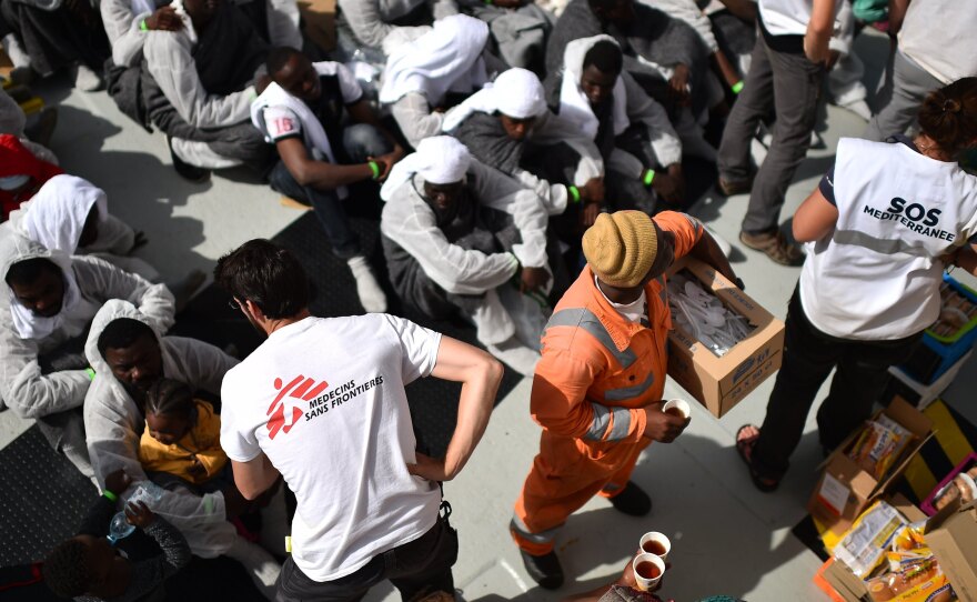 Members of Médecins Sans Frontières (Doctors Without Borders) and SOS Méditerranée distribute food to migrants and refugees aboard the rescue ship Aquarius on May 25, a day after a rescue operation off the Libyan coast.
