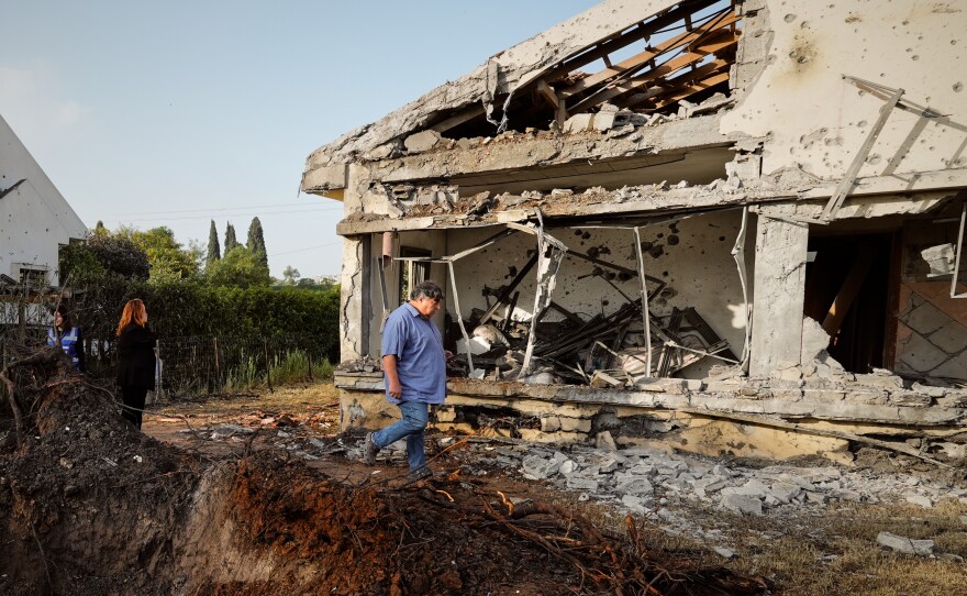 People inspect homes damaged by a projectile launched from Lebanon, in Haniel central Israel, on Thursday.
