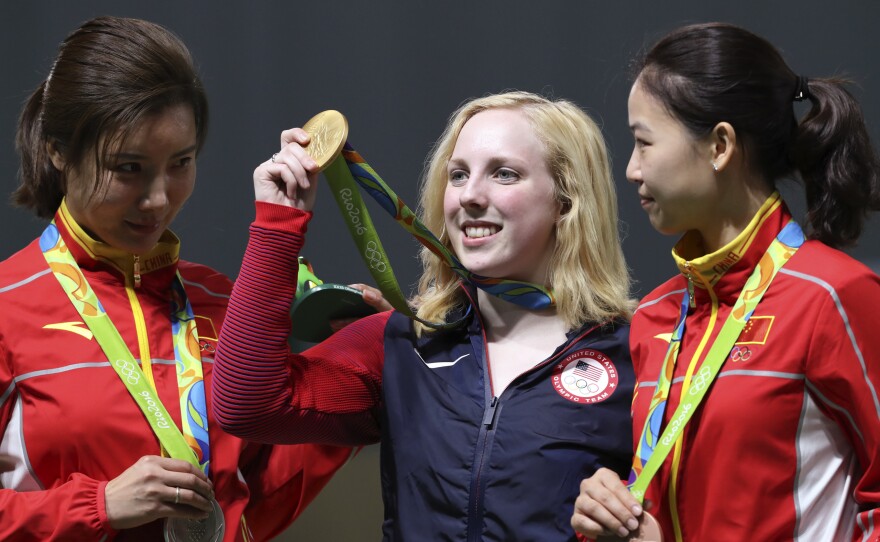 Ginny Thrasher (center) of the U.S. holds her gold medal for the women's 10-meter air rifle competition, the first gold awarded at the Rio Games. China's Du Li (left), won the silver and Yi Siling, also of China, won the bronze on Saturday.