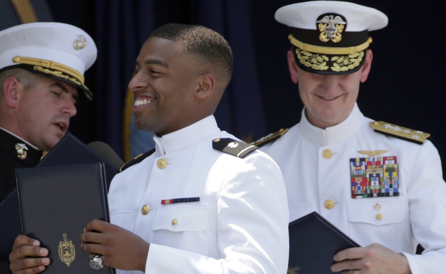 Keenan Reynolds (center), Baltimore Ravens' sixth round NFL draft pick, carries his diploma during the Naval Academy's graduation in May 2016. Trump's order on Wednesday would allow more military graduates to defer service in order to pursue professional sports careers.
