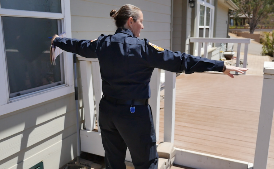 Cal Fire Forestry Technician Brandi McLaughlin measures distance of potentially combustible items in a home in Jamul.